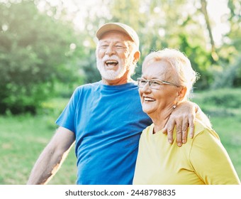 Smiling active senior couple jogging exercising and having fun and laughing together taking a break in the park - Powered by Shutterstock