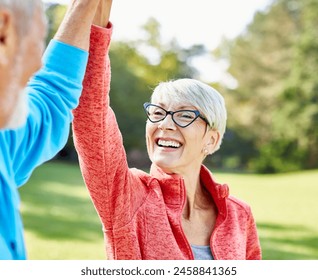 Smiling active senior couple jogging exercising and having fun and giving high five together taking a break in the park - Powered by Shutterstock