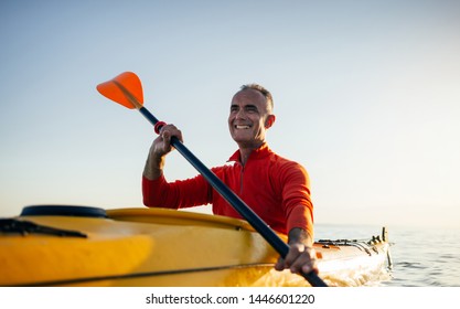 Smiling active senior man paddling kayak. Kayaking, paddling, canoeing, vacation - Powered by Shutterstock