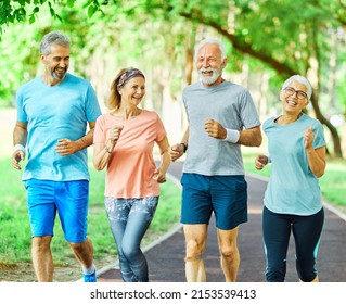 Smiling Active Senior People Jogging Together In The Park