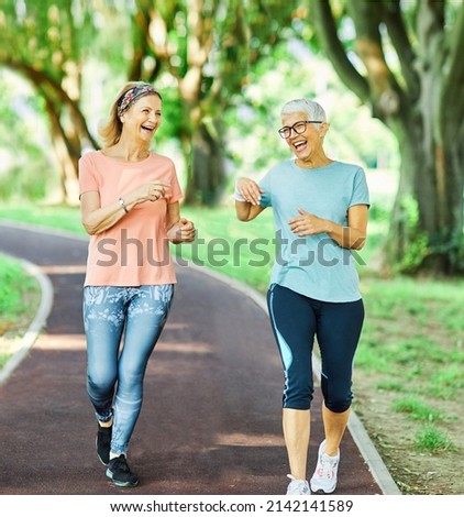 Smiling active senior people jogging together in the park