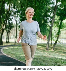 Smiling active senior woman jogging running and walking doing fitness in the park - Powered by Shutterstock