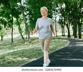 Smiling active senior woman jogging running and walking doing fitness in the park - Powered by Shutterstock