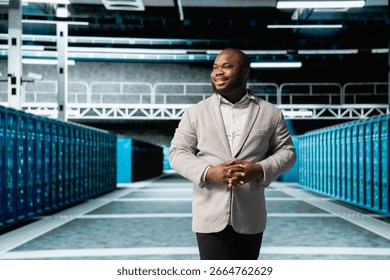 Smiling admin walking in server room, overseeing mainframes gear used for managing databases. Jolly IT specialist in data center workplace doing checkup on rackmounts storing information