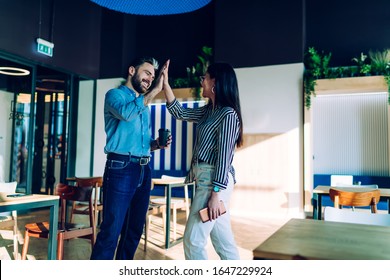 Smiling Adult Male Manager In Casual Formal Wear Praising Female Coworker And Giving High Five At Modern Stylish Work Space