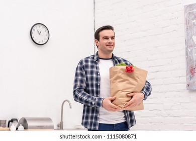 Smiling Adult Man Carrying Grocery Store Bag At Kitchen