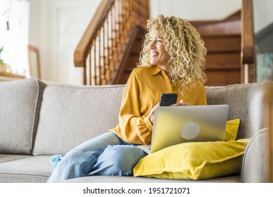 Smiling adult young woman sit relax on couch using modern laptop browsing unlimited wireless internet, happy young people freelancer work on computer typing texting from home, technology concept
