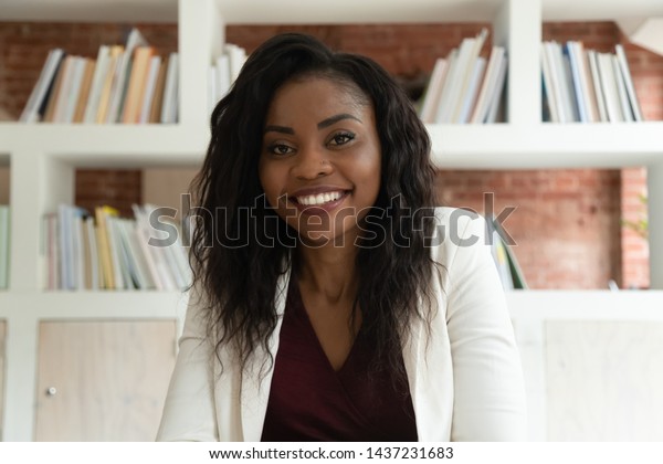Smiling african american business woman coach\
teacher hr looking at camera, happy black lady making video call\
for online job interview by webcamera recording training webinar,\
webcam view, portrait