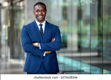 Smiling african american businessman CEO standing proud with arms crossed outside office workplace, colorful, reflective glass building, copy space - Shutterstock ID 1475638346
