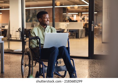 Smiling african american businessman with disability using laptop in wheelchair. Unaltered, creative business, workplace, success, positive emotion. - Shutterstock ID 2183685299