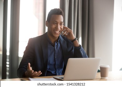 Smiling African American Businessman, Lawyer, Real Estate Agent, Banker Or Consultant Making Cell Phone Call To Client At Office. Black Happy Male Employee Listening To Good News Using Cellphone