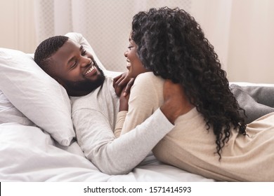 Smiling African American Couple Having Fun In Bed, Embracing And Flirting With Each Other, Closeup