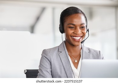 Smiling african american customer care representative working with headset in office. Black woman telemarketing agent working in call center. Call center agent with headset makinga video call. - Powered by Shutterstock