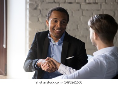 Smiling African American Employee Shaking Hand Of Colleague, Client At Meeting, Caucasian Mentor Greeting Intern, New Worker Getting Acquainted, Successful Deal Or Job Interview, Hiring Process