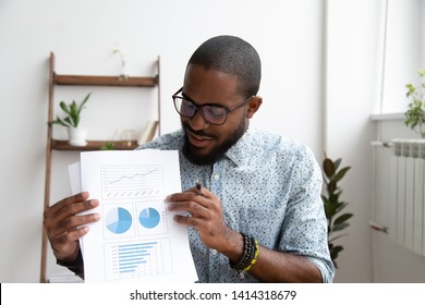 Smiling African American Executive Manager Making Presentation Showing Sales Charts Work Results. Head Shot Black Employee Talking About Increasing Revenue And Productivity Looking At Financial Report