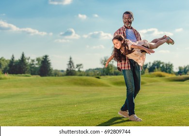 Smiling African American Grandfather Playing With Granddaughter At Sunny Day