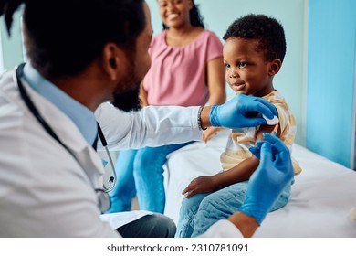 Smiling African American kid getting vaccinated at medical clinic.  - Powered by Shutterstock