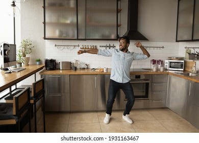 Smiling African American Man Dancing, Having Fun In Modern Kitchen, Happy Young Male Moving To Favorite Music In The Morning Alone, Preparing Breakfast, Starting New Day, Enjoying Leisure Time