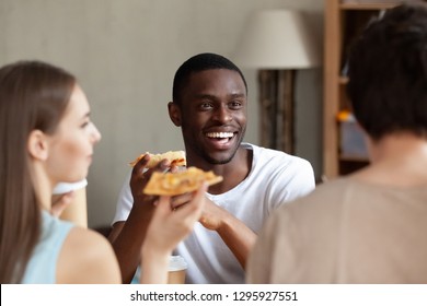 Smiling African American Man Eating Pizza, Chatting With Friends In Cafe, Black Guy Laughing At Funny Joke, Enjoying Delicious Italian Fast Food In Pizzeria, Students Feeling Happy, Having Lunch