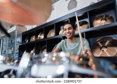 Smiling African American Man Playing Blurred Drums In Music Store