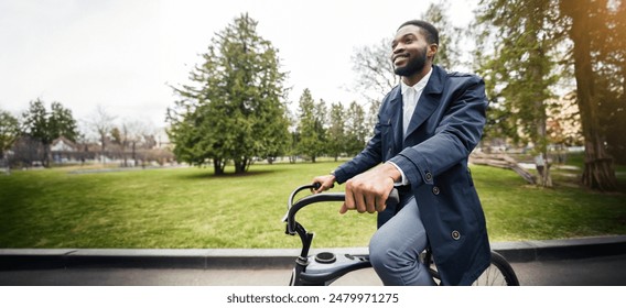 Smiling African American man in suit riding a bicycle in a park with green trees and grass in the background. - Powered by Shutterstock