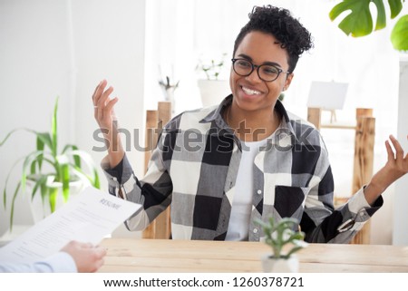 Smiling African American millennial woman talk making good first impression at interview, excited black girl speak during hiring process with employer, happy female intern laugh at recruitment meeting