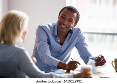 Smiling african american professional manager advisor designer talking with client listen to customer preferences at business meeting, diverse colleagues having conversation share design idea at work - Shutterstock ID 1410222932