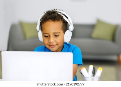 Smiling african american schoolboy doing homework while sitting at table at home - Shutterstock ID 2190192779