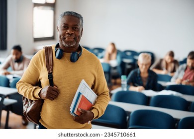 Smiling African American senior man attending a class in lecture hall and looking at camera. - Powered by Shutterstock