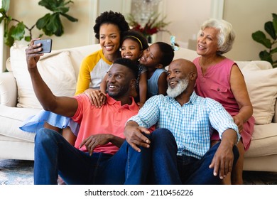 Smiling african american three generation family taking a selfie sitting together on couch at home. family, love and togetherness concept, unaltered. - Powered by Shutterstock