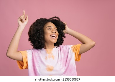 Smiling African American Woman Dancing Looking Away Isolated On Pink Background. Happy Curly Haired Teenager Wearing Stylish Tie Dye T Shirt Having Fun 