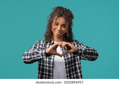 Smiling african american woman showing sign of shape heart. Positive teenager girl on blue. Love. Women health, volunteering, charity donation, gratitude symbol, flirting concept. High quality photo - Powered by Shutterstock