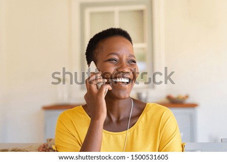 Smiling african american woman talking on the phone. Mature black woman in conversation using mobile phone while laughing. Young cheerful lady having fun during a funny conversation call.