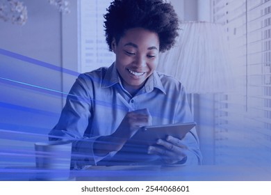 Smiling African American woman using a tablet. The woman is engaged with her tablet digital device, showing a happy expression. The woman is enjoying her time with the tablet. Photo with blue overlay. - Powered by Shutterstock