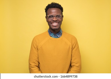 Smiling African American Young Man Inyellow Sweater Smiling Confident At Camera. Studio Shot. Positive Facial Human Emotion.