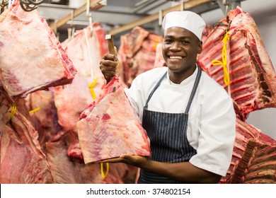 smiling african butcher handing beef in slaughterhouse - Powered by Shutterstock