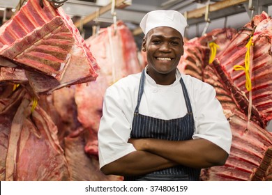 smiling african butcher standing in meat storeroom - Powered by Shutterstock