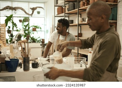 Smiling African ceramists working together in a pottery studio - Powered by Shutterstock