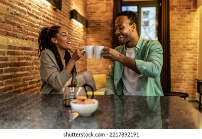 Smiling african couple in love drinking morning coffee at home during weekend - Powered by Shutterstock