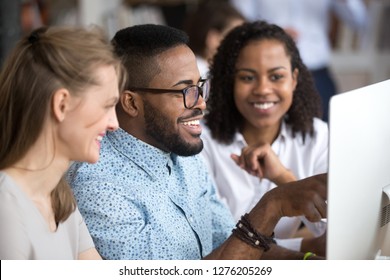 Smiling african employee team leader explaining computer task online project in office, happy black worker mentor talking teaching helping coworkers group, diverse colleagues work together on pc - Shutterstock ID 1276205269