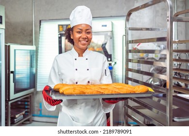 Smiling african  female bakers looking at camera..Chefs  baker in a chef dress and hat, cooking together in kitchen.Professional cooks in uniform preparing meals for a restaurant. - Shutterstock ID 2189789091