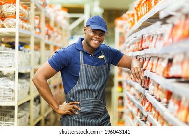 Smiling African Hardware Store Worker Standing By The Fasteners Aisle 