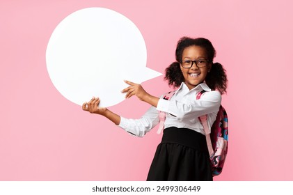 Smiling African Schoolgirl Holding Speech Bubble Posing Over Yellow Background In Studio. Mockup - Powered by Shutterstock