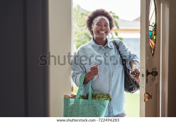 Smiling African Woman Walking Through Front Stock Photo