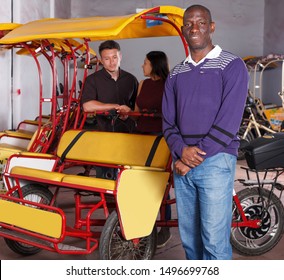 Smiling African-American pedicab driver offering  rickshaw cycle tour