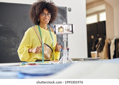 Smiling African-American Teacher Shoots Tutorial For Fashion Design Class At Table