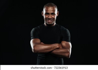 Smiling Afro American Sports Man With Arms Folded Looking At Camera, Isolated On A Black Background