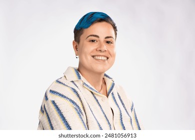 Smiling androgynous person with blue hair in casual fashion - friendly and inclusive expression, modern and vibrant look - simple background, diversity and pride. - Powered by Shutterstock