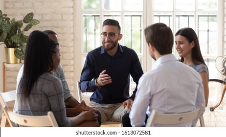 Smiling Arabic male mentor or coach sit in circle with diverse patients counseling help overcome life problems, multiethnic young people share thoughts speak at psychological therapy session