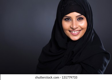 smiling Arabic woman in traditional clothing on black background